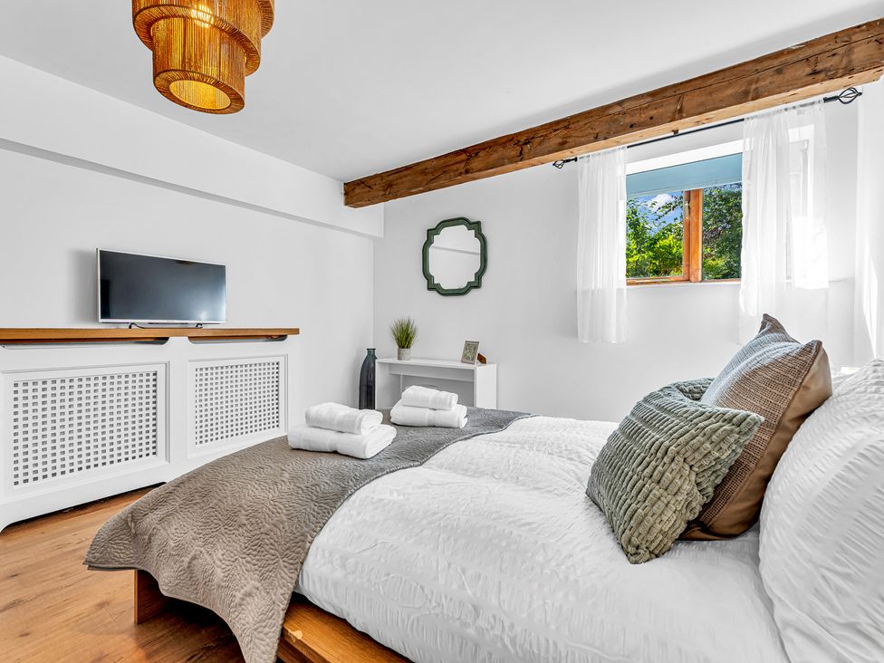 A bedroom with a bed and television at Oxhay Barn, Newcastle