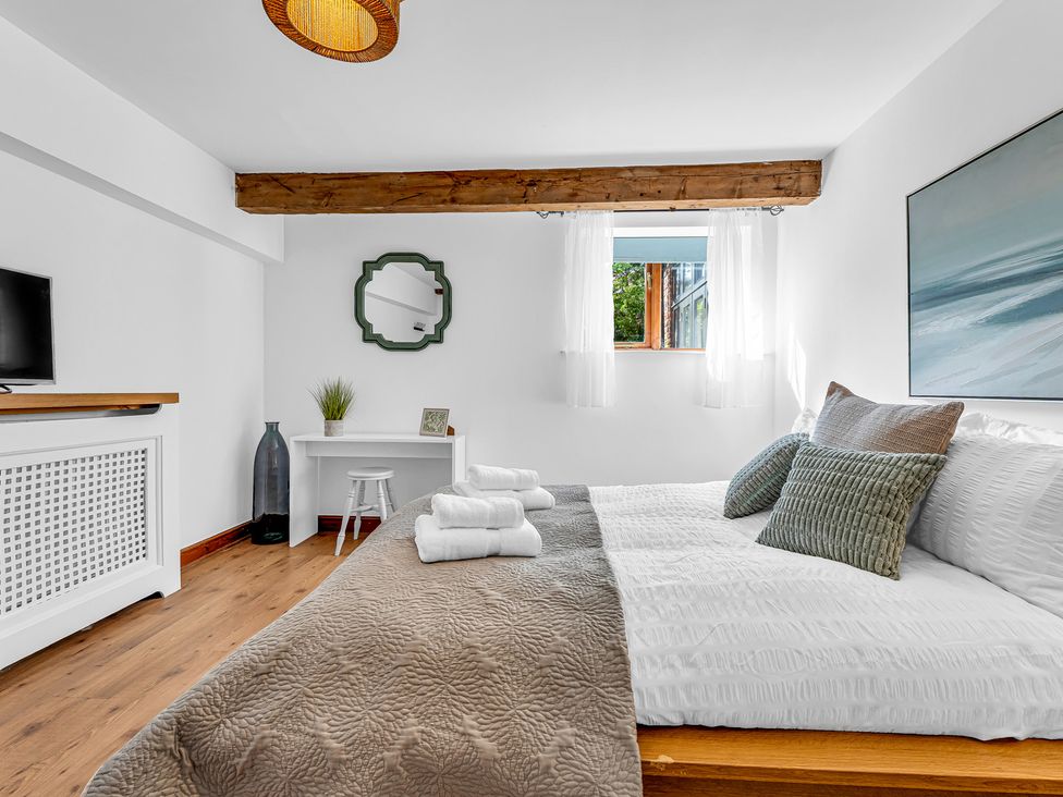 A bedroom with a bed and television at Oxhay Barn Newcastle