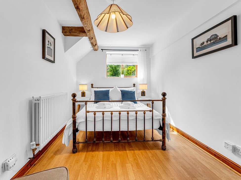 A bedroom with a bed and lamps at Oxhay Barn Newcastle