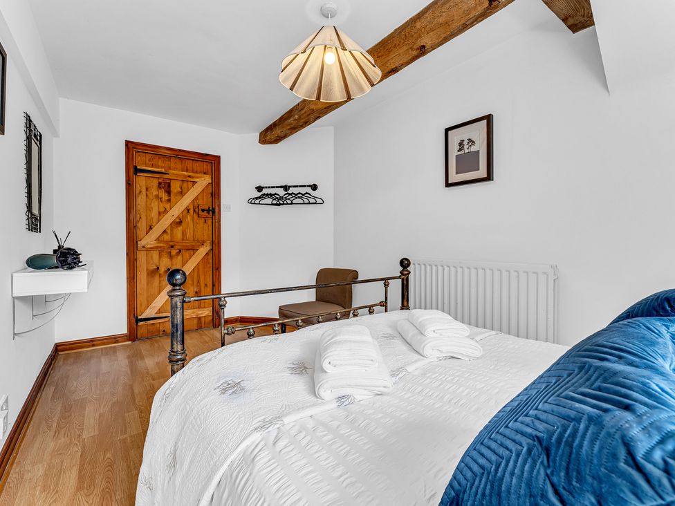 A bedroom with a bed and chair at Oxhay Barn Newcastle