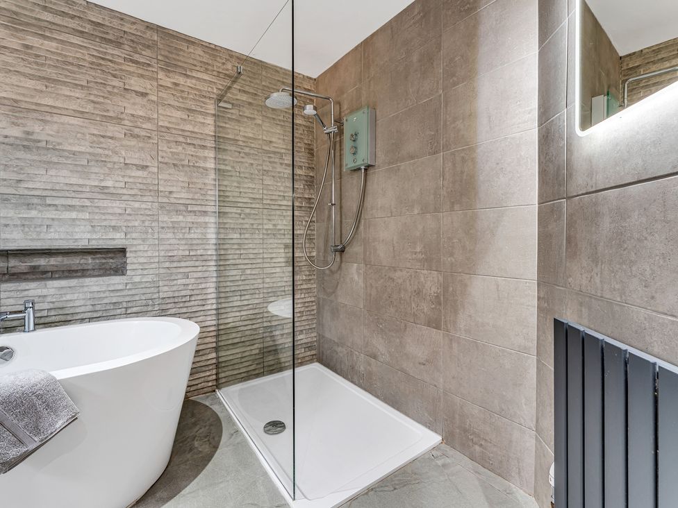 A bathroom with a bathtub and shower at Oxhay Barn Newcastle