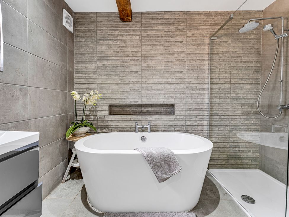 A bathroom with a bathtub and shower at Oxhay Barn Newcastle
