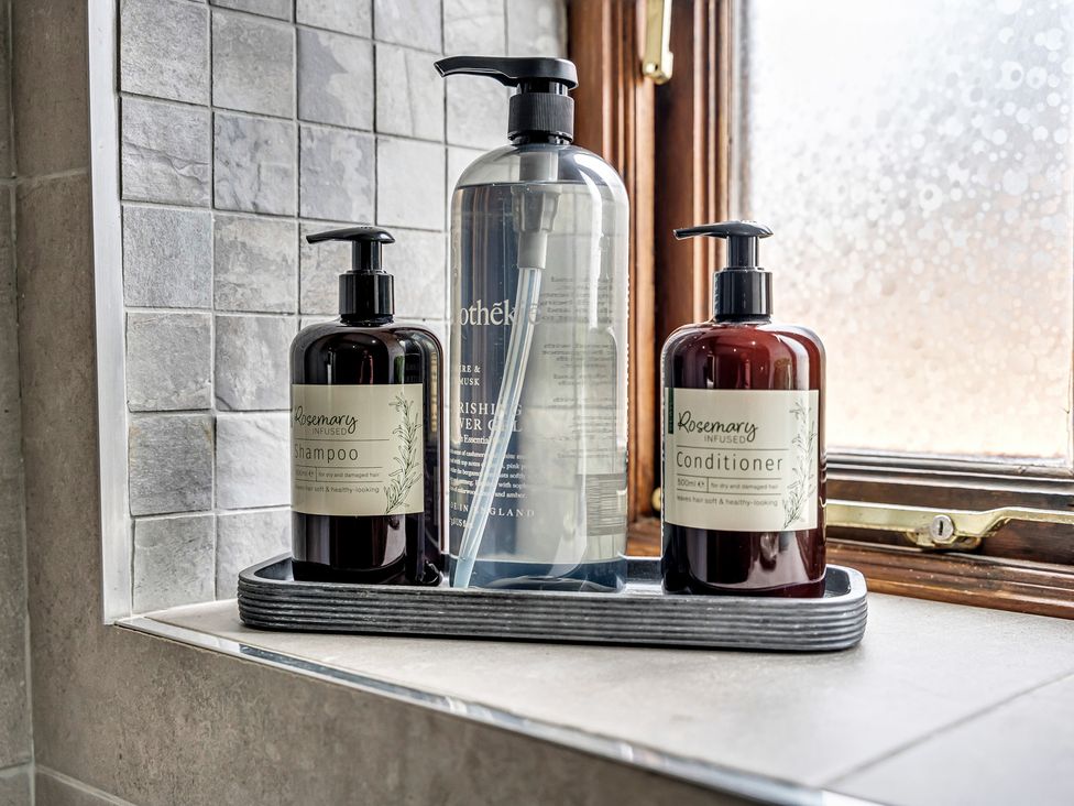 A tray with shampoo and conditioner bottles near a window at Oxhay Barn Newcastle