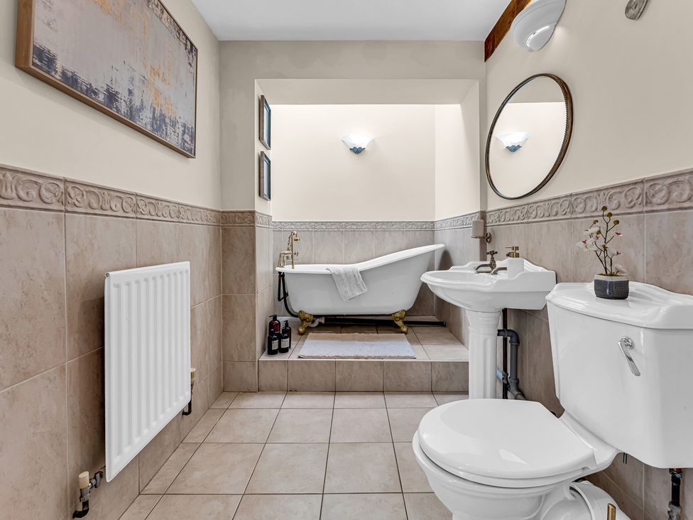 A bathroom with a bathtub and wash basin at Oxhay Barn Newcastle