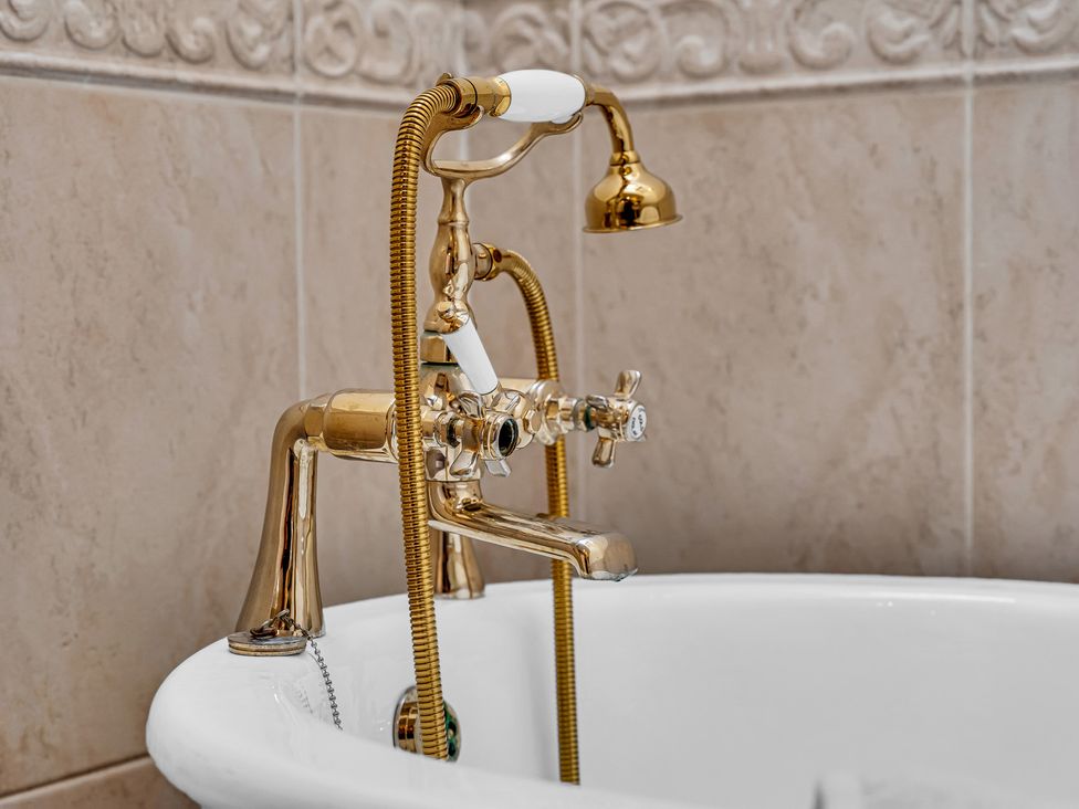 A bathtub faucet with a handheld showerhead at Oxhay Barn Newcastle