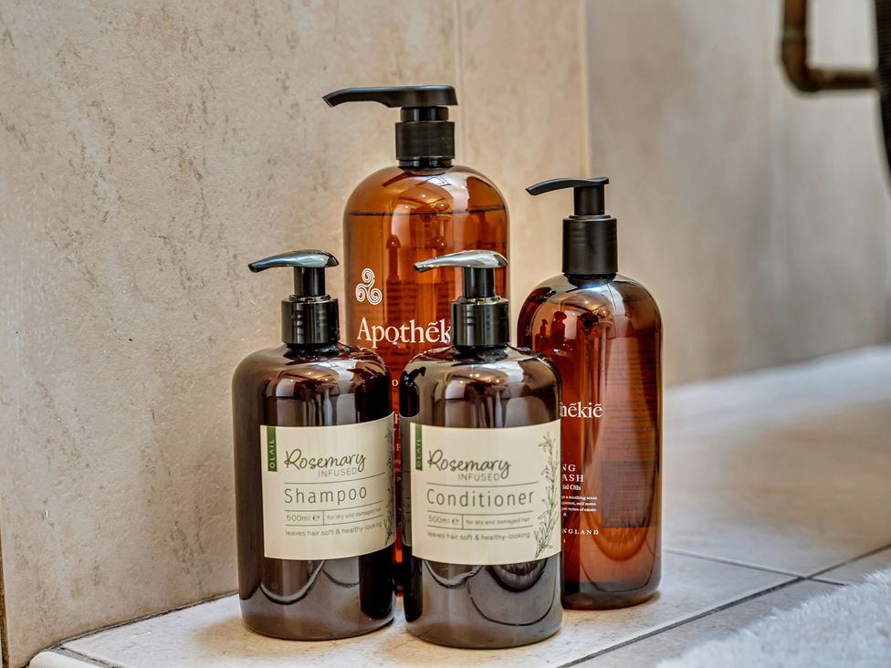 Bathroom with shampoo, conditioner, and body wash bottles at Oxhay Barn Newcastle