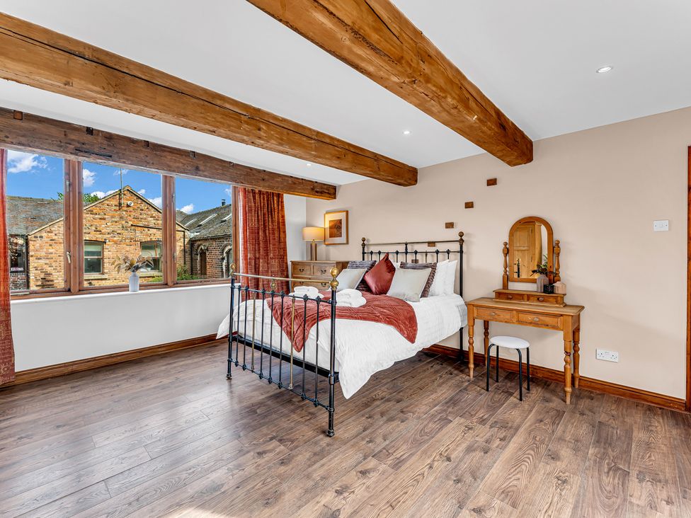 A bedroom with a bed and table at Oxhay Barn Newcastle
