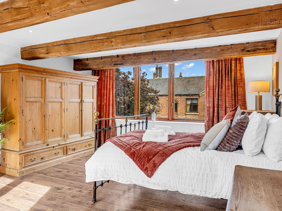 A bedroom with a bed, wardrobe, and lamp at Oxhay Barn in Newcastle