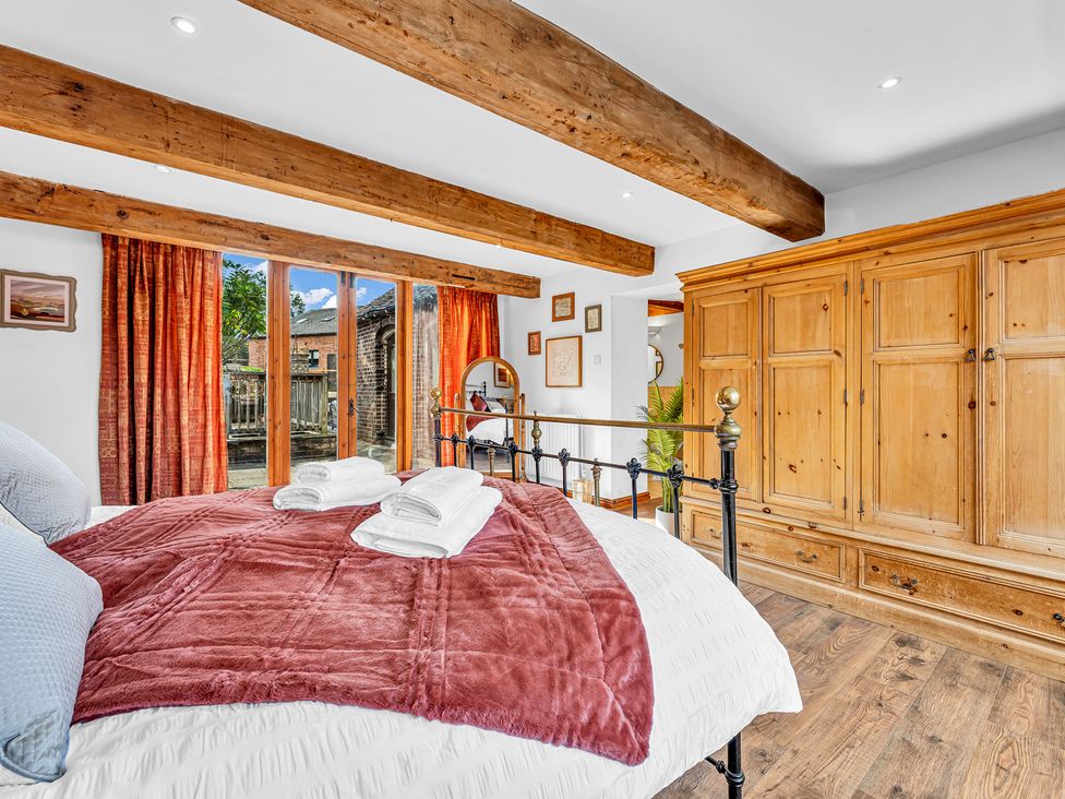 A bedroom with a bed and wardrobe at Oxhay Barn Newcastle