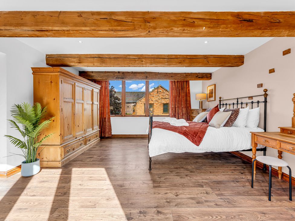 A bedroom with a bed and wardrobe at Oxhay Barn Newcastle