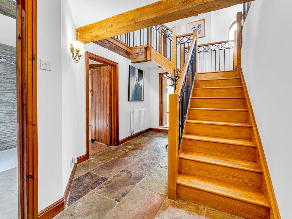 A hallway with a staircase and doors at Oxhay Barn Newcastle