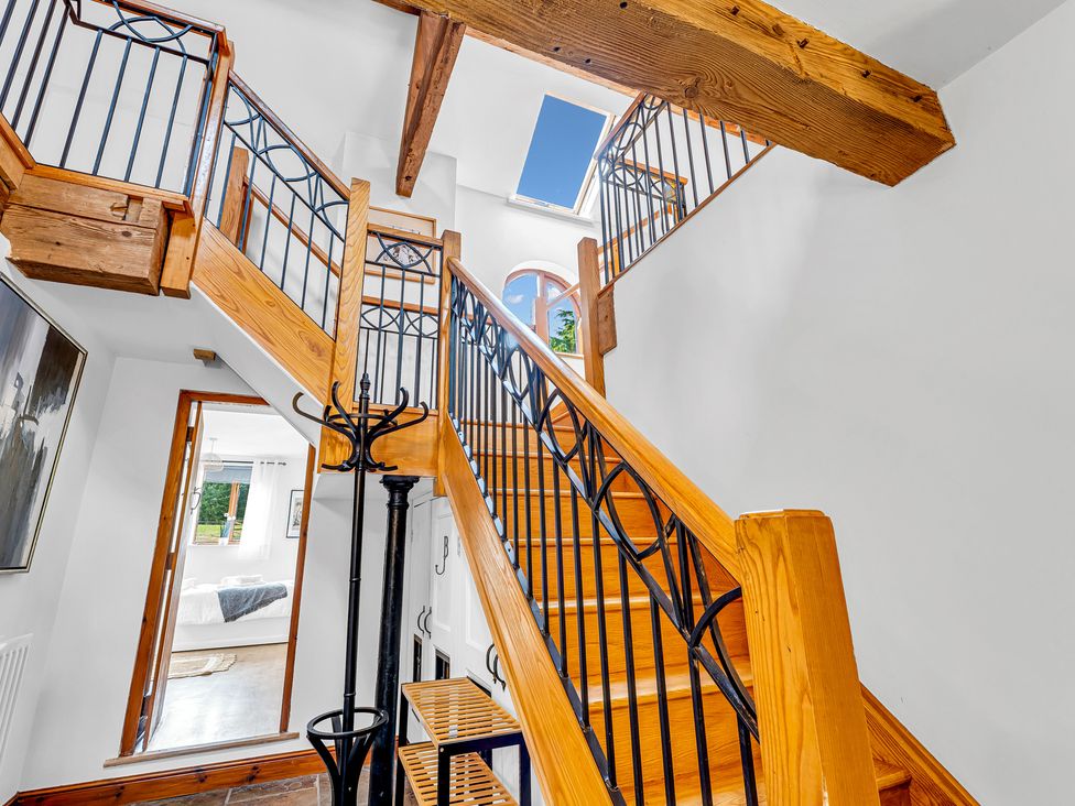 A staircase with wood railings and a door at Oxhay Barn Newcastle