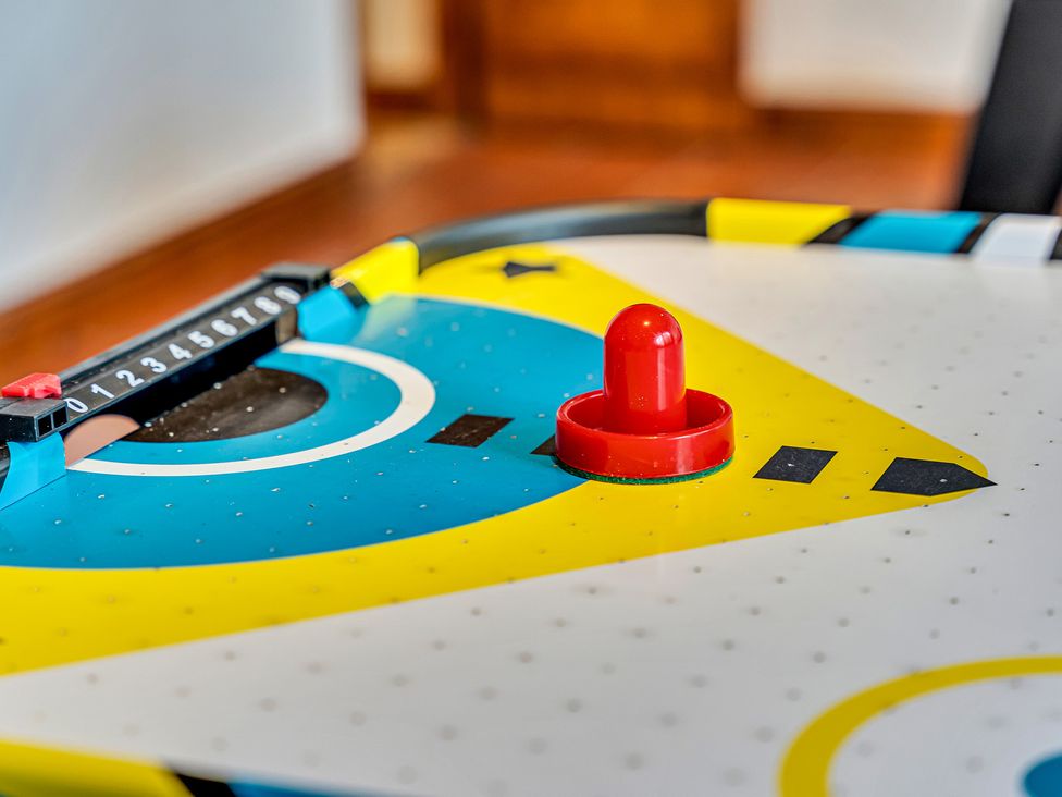 An air hockey table with a red puck and scoring system at Oxhay Barn Newcastle
