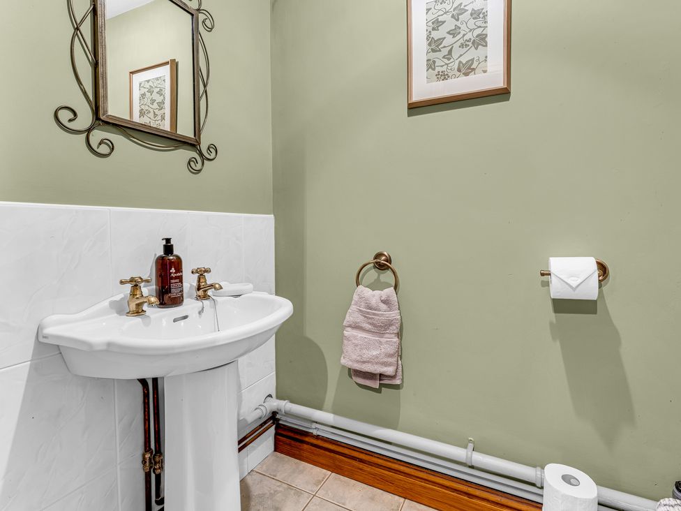 A sink with a mirror and towel holder in the bathroom at Oxhay Barn Newcastle