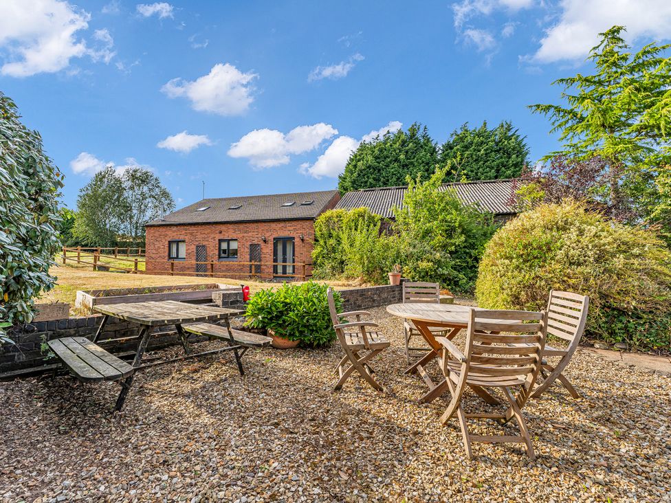 A garden with a table and chairs at Oxhay Barn in Newcastle