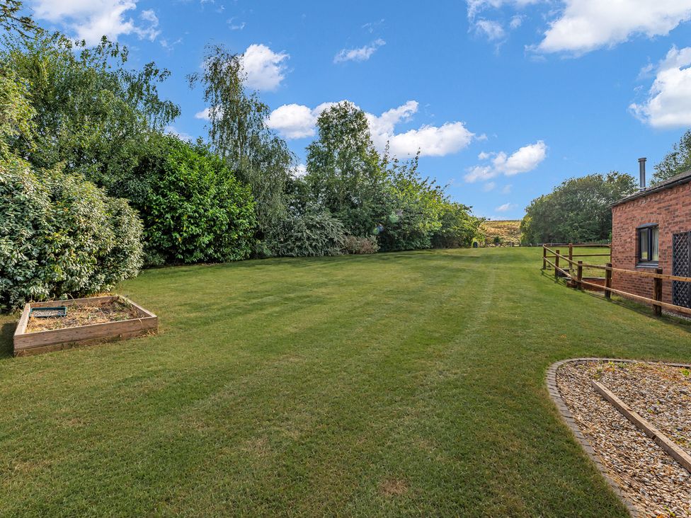 A garden with grass and trees at Oxhay Barn Newcastle
