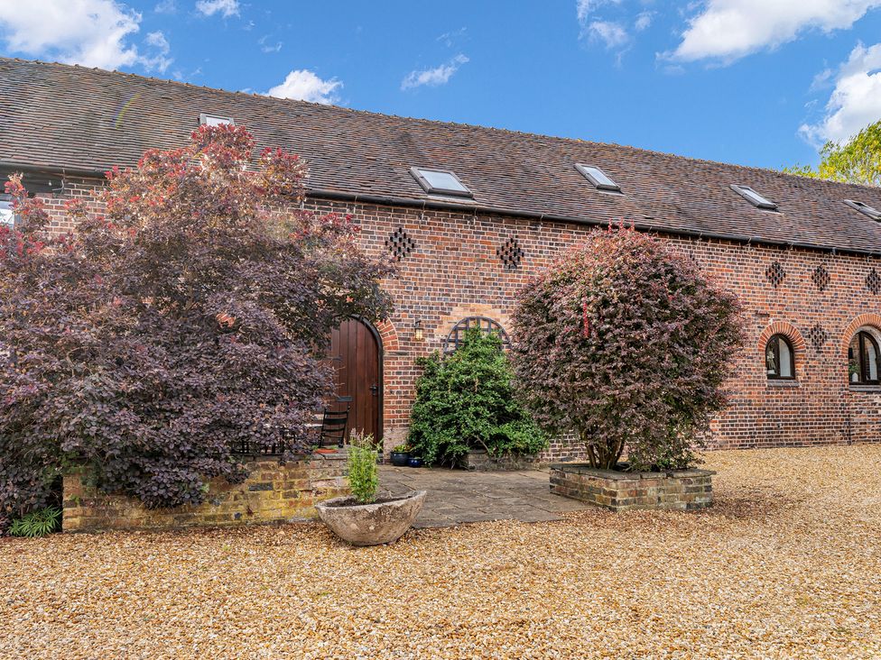 An exterior view of a building with trees and gravel at Oxhay Barn Newcastle