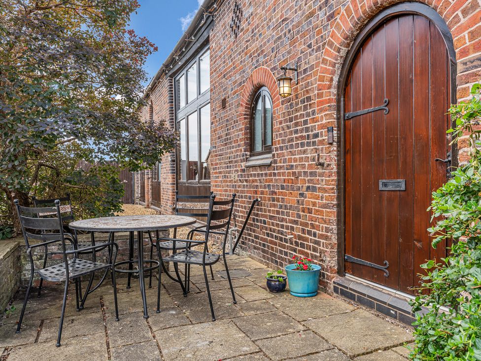 An outdoor seating area with a table and chairs at Oxhay Barn Newcastle