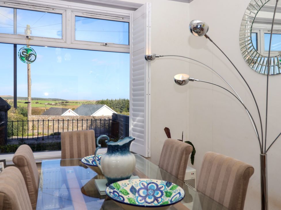 A dining room featuring a table with chairs and a view at Angels Place in Yelverton