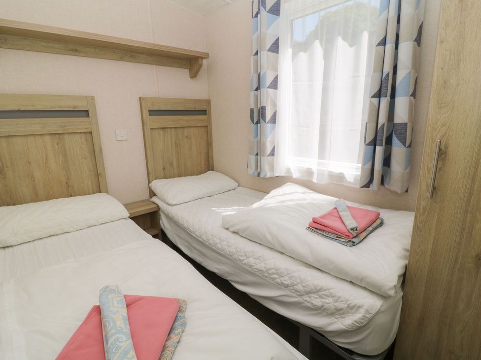 A bedroom with two beds and a window at Feather Tor in Tavistock