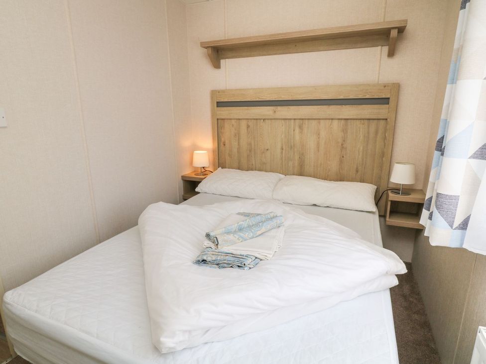 A bedroom with a bed and bedside lamp at Feather Tor in Tavistock