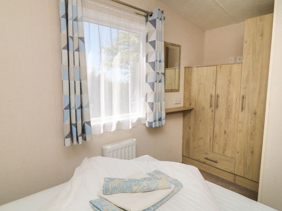 A bedroom with a window and wardrobe at Feather Tor in Tavistock