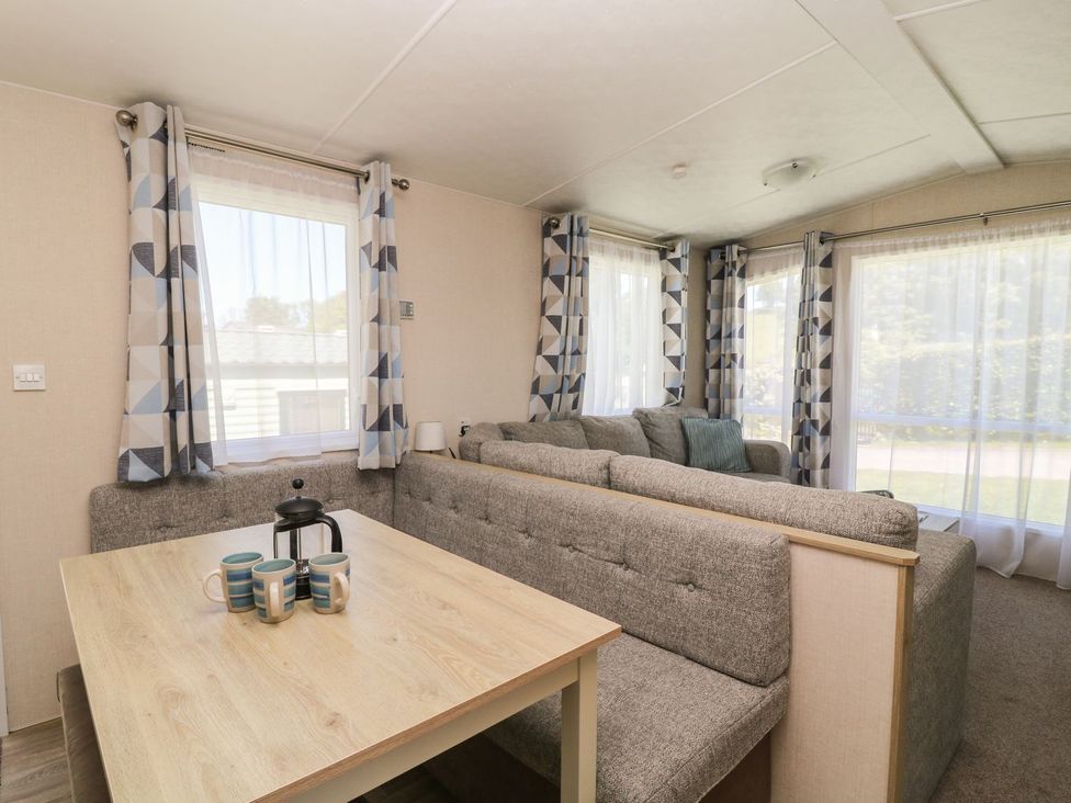 A living room with a dining table and sofa at Laughter Tor in Tavistock