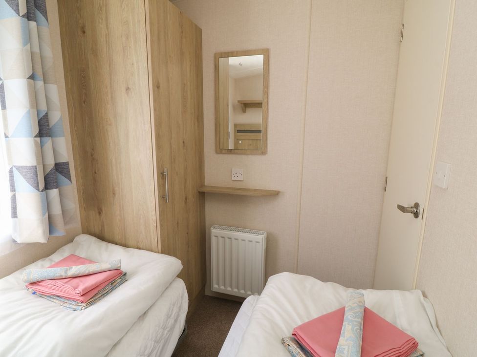 A bedroom with two beds and a wardrobe at Laughter Tor in Tavistock