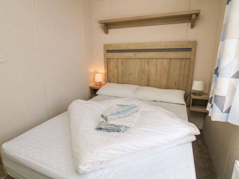 A bedroom with a bed and lamp at Laughter Tor in Tavistock