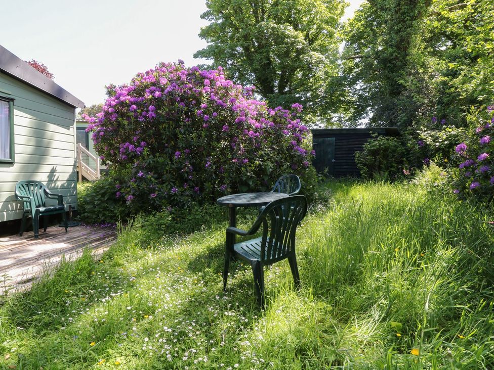 A table and chairs in a garden with flowers at Laughter Tor Tavistock
