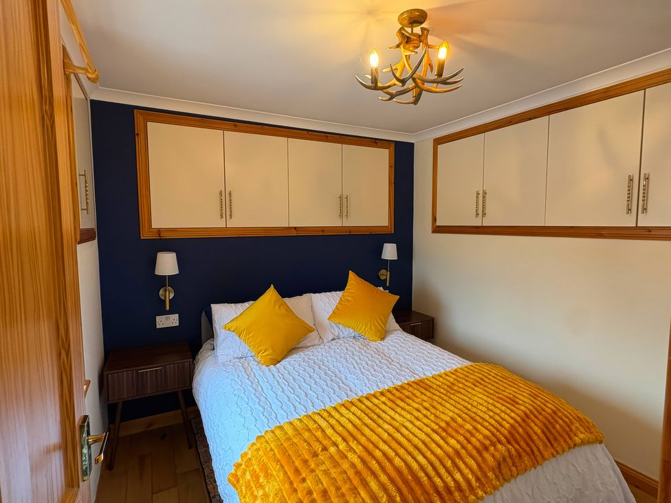 A bedroom with bed and lamp at Bothan Beag, Daliburgh, Isle Of South Uist