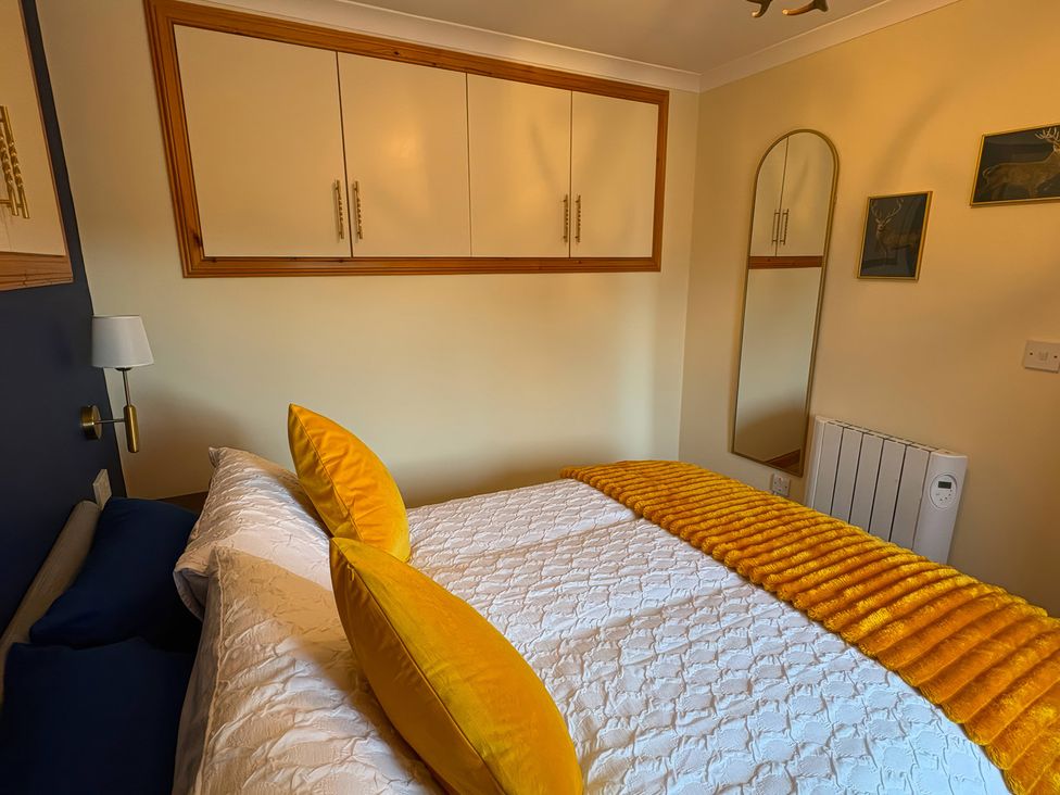 A bedroom with a bed and storage cabinets at Bothan Beag, Daliburgh, Isle Of South Uist