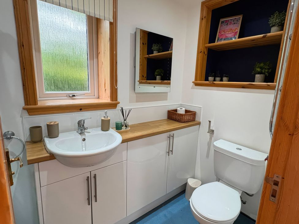 A bathroom with a sink, toilet, and mirror at Bothan Beag, Daliburgh, Isle Of South Uist