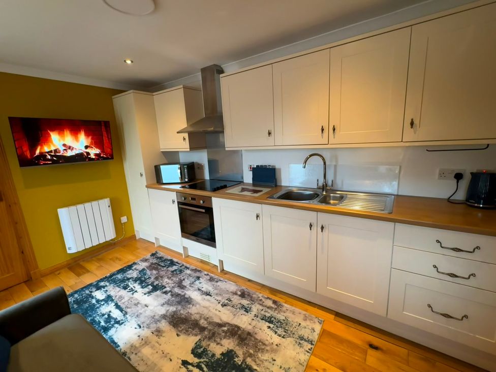 A kitchen with appliances and a television at Bothan Beag, Daliburgh, Isle Of South Uist