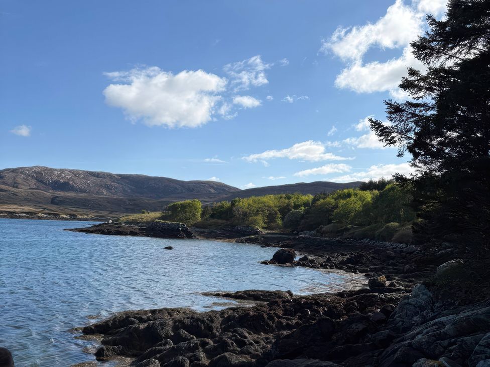 A shoreline with water and trees at Bothan Beag Daliburgh, Isle Of South Uist