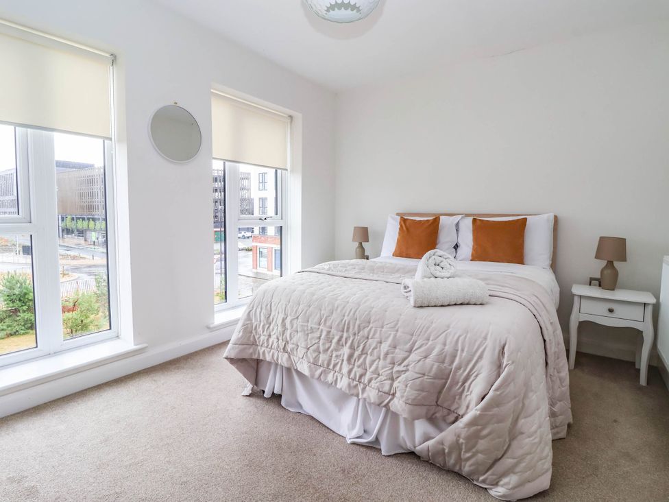 A bedroom with a bed and windows at Blanket Row in Hull