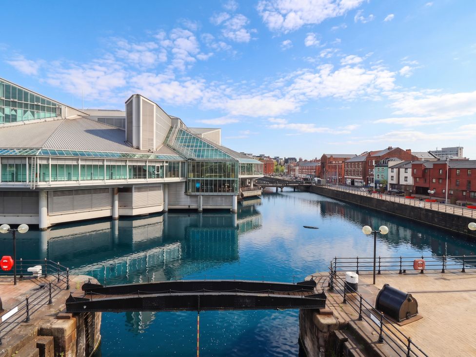 A view of a waterway with buildings and a bridge at Blanket Row in Hull