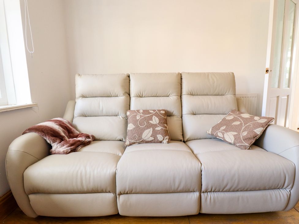 A sofa with cushions and a throw blanket at Mariner's Nook in Cleethorpes