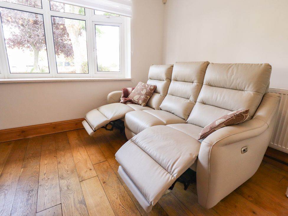 A reclining sofa with cushion near a window at Mariner's Nook in Cleethorpes