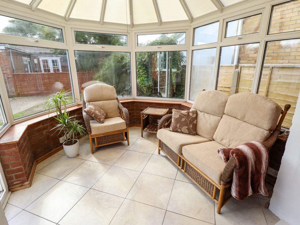 A conservatory with seating and plants at Mariner's Nook in Cleethorpes