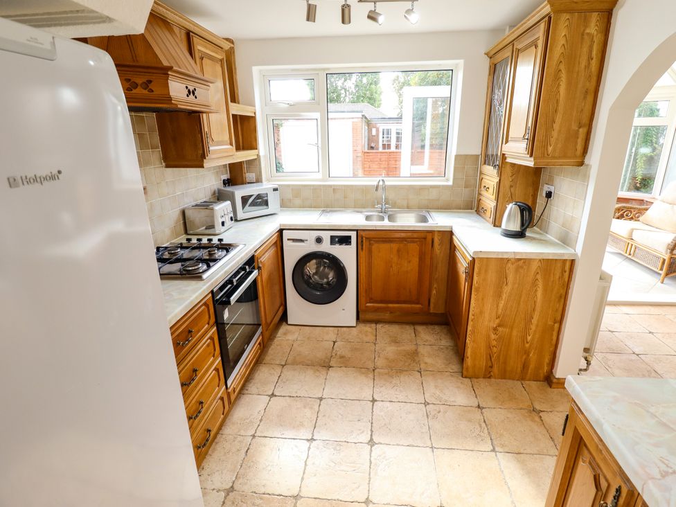 A kitchen with appliances including a washing machine and refrigerator at Mariner's Nook in Cleethorpes