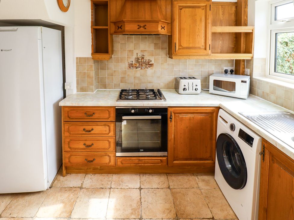 A kitchen with a fridge, oven, stove, and washing machine at Mariner's Nook in Cleethorpes
