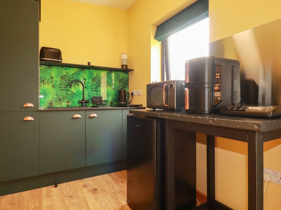 A kitchen with appliances including a refrigerator and microwave at The Hyde, Tazamble cottage, Launceston