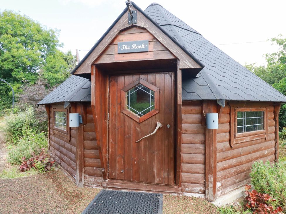 A small cabin with a wooden door and multiple windows at The Rook in Launceston