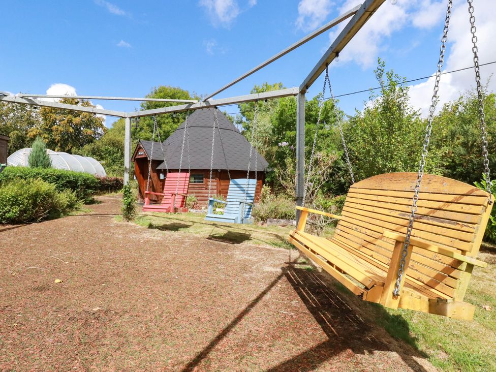 A garden with a wooden swing and garden shed at The Hyde, Tazamble cottage Launceston