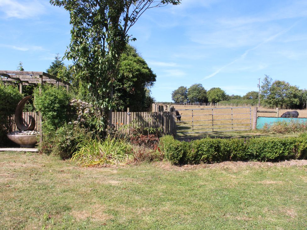 A garden with a water trough and a fence at The Hyde near Launceston