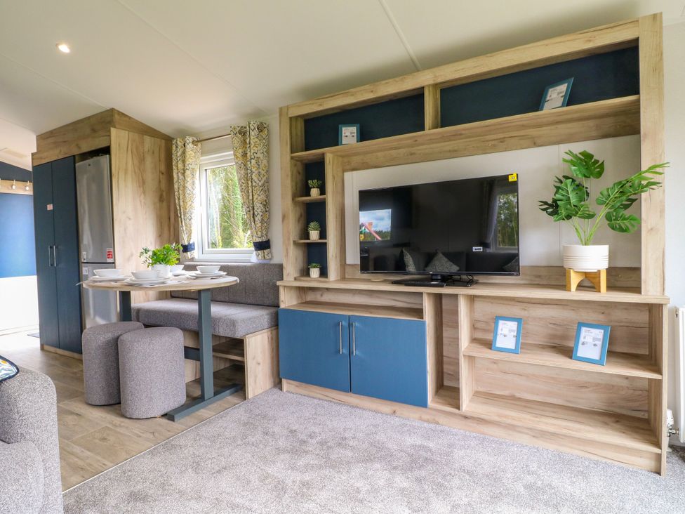 A living room with a table and chairs at Barn Owl Lodge in Coalville