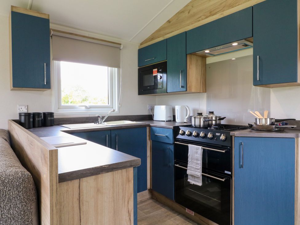 A kitchen with blue cabinetry and appliances at Falcon Lodge in Coalville