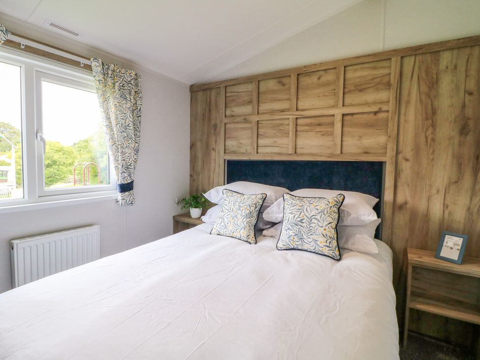 A bedroom with a bed and window at Falcon Lodge in Coalville