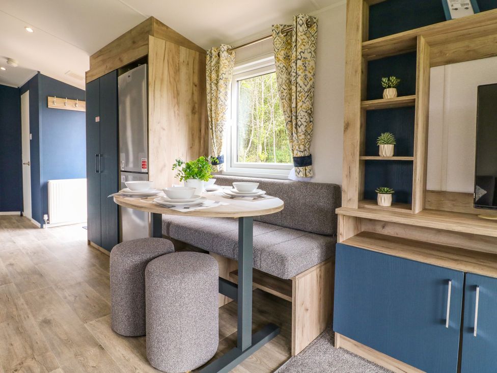 A dining area with a table and stools at Red Kite Lodge in Coalville